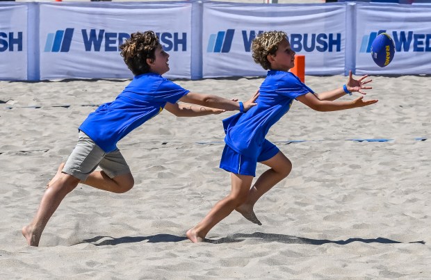 Kids participate in tryouts and warm-ups at the Beach Football...