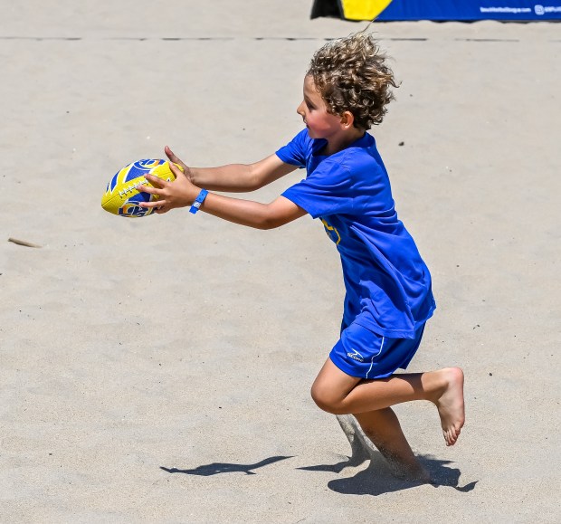 Kids participate in tryouts and warm-ups at the Beach Football...