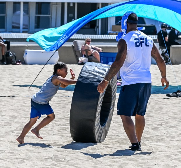 Los Angeles Chargers linebacker Denzel Perryman helps lead kids through...