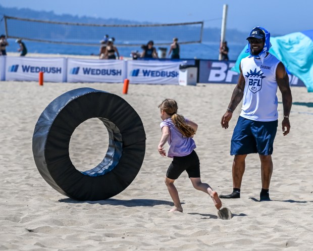 Los Angeles Chargers linebacker Denzel Perryman helps lead kids through...