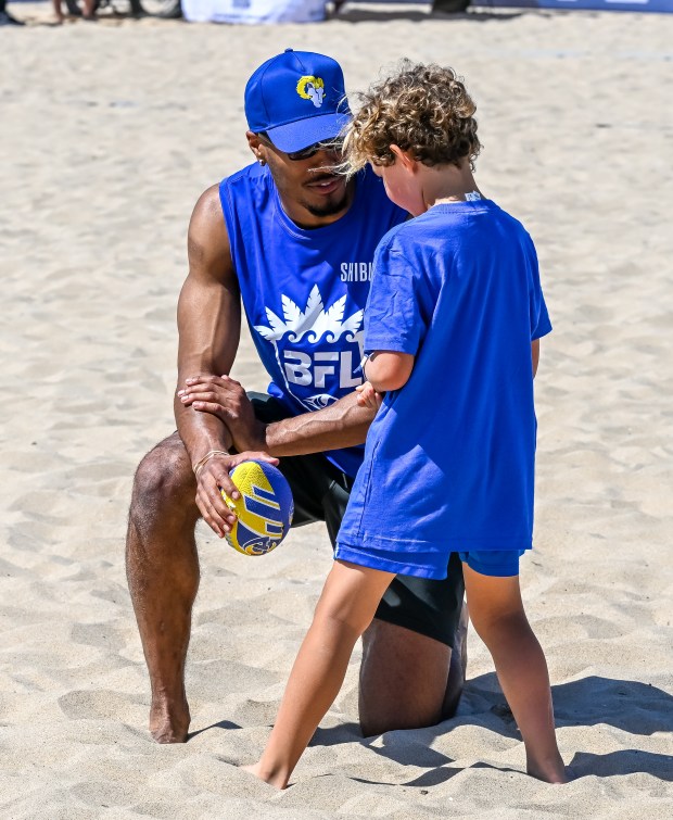 Los Angeles Rams safety Quentin Lake helps lead kids through...