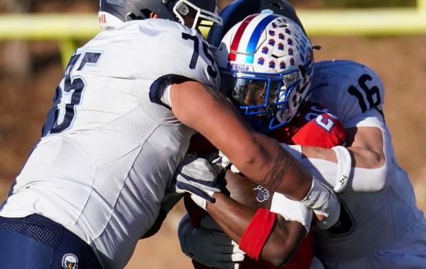 Cherry Creek High School's Elijah S. Cromwell (26) is stopped by Valor Christian High School's Zay Amaro (75) and Dakota Rich (16) at the Stutler Bowl, Saturday, Nov. 30, 2024 in Greenwood Village. Cherry Creek High School blew out Valor Christian High School winning 42-17. (Rebecca Slezak/Special to The Denver Post)