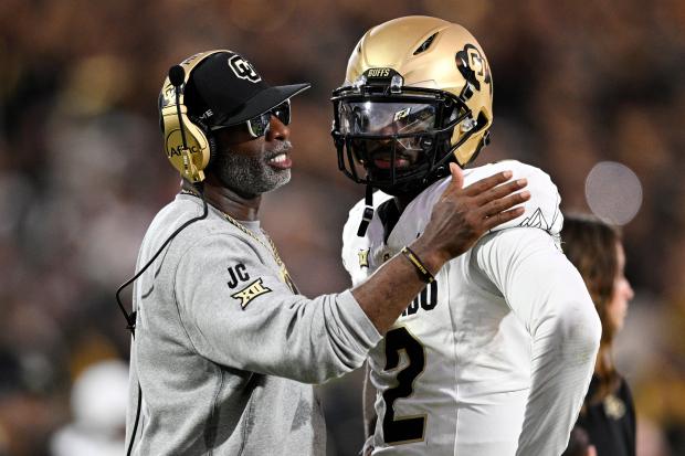 Colorado coach Deion Sanders talks with quarterback Shedeur Sanders during a timeout in the second half against Central Florida on Sept. 28, 2024, in Orlando, Fla. (AP Photo/Phelan M. Ebenhack)