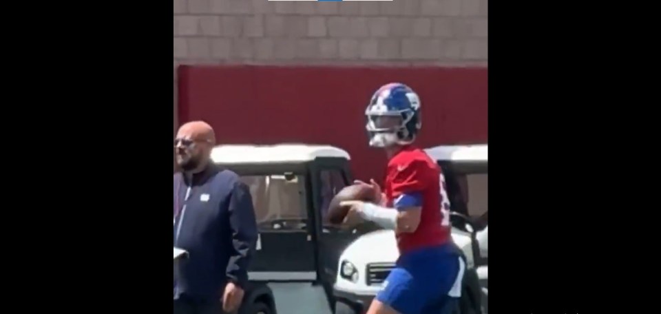 Screenshot of a football player in a red jersey holding a football.