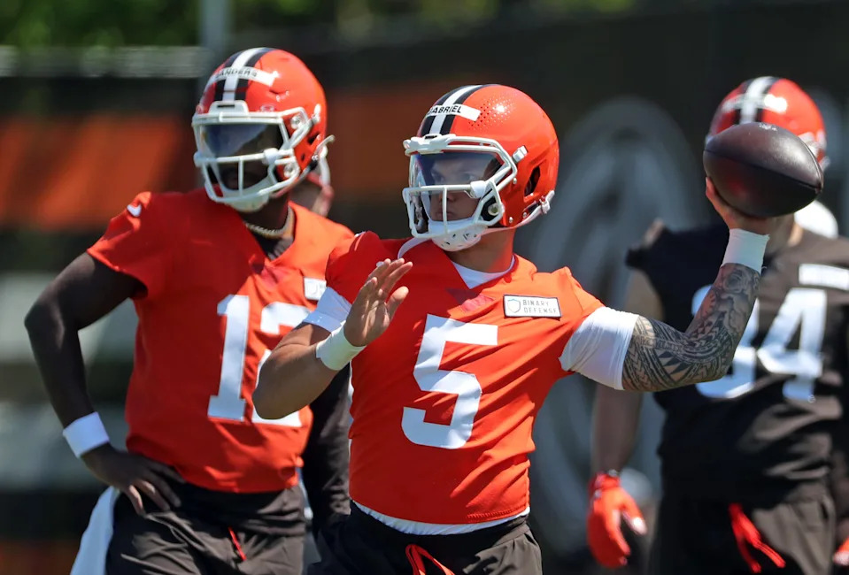 Cleveland Browns quarterback Dillon Gabriel (5) throws as quarterback Shedeur Sanders (12) looks on during NFL rookie minicamp at the Cleveland Browns training facility on Friday, May 9, 2025, in Berea, Ohio.