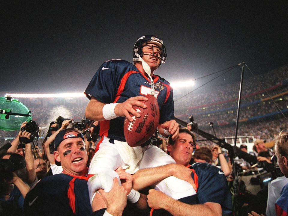 John Elway carried by teammates after winning Super Bowl XXXII.