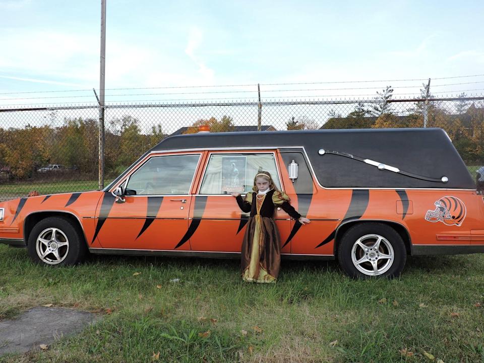 Brian Robertson's daughter, Alexis, stands in front of the hearse while dressed as a guest haunter for the Dent Schoolhouse.