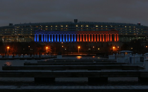 The eastern colonnade of Soldier Field is illuminated with the...