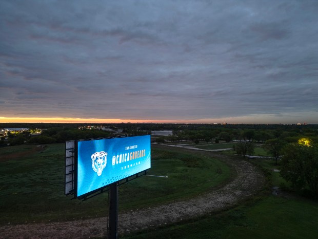 A Chicago Bears digital billboard located just off of Route 53 flashes advertisements at sunrise at the former Arlington International Racecourse on May 23, 2025, in Arlington Heights. (Stacey Wescott/Chicago Tribune)