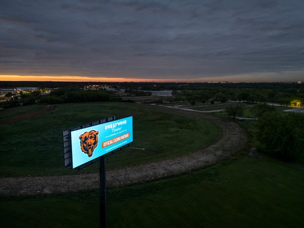 A Chicago Bears digital billboard glows at sunrise just off...