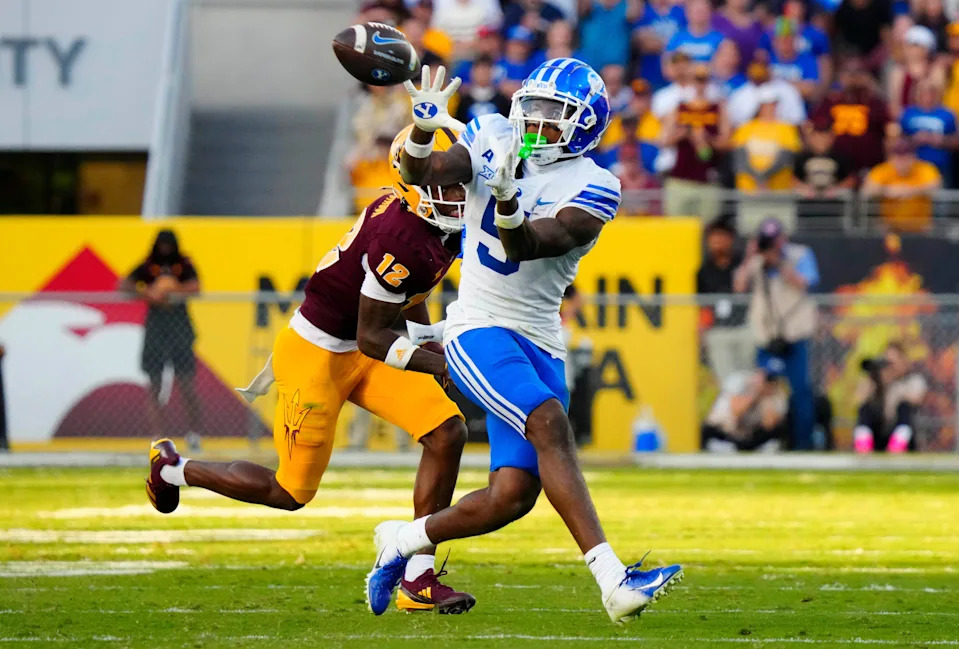 BYU wide receiver Darius Lassiter (5) makes a catch against Arizona State defensive back Javan Robinson (12) during the second half at Mountain America Stadium in Tempe on Nov. 23, 2024.