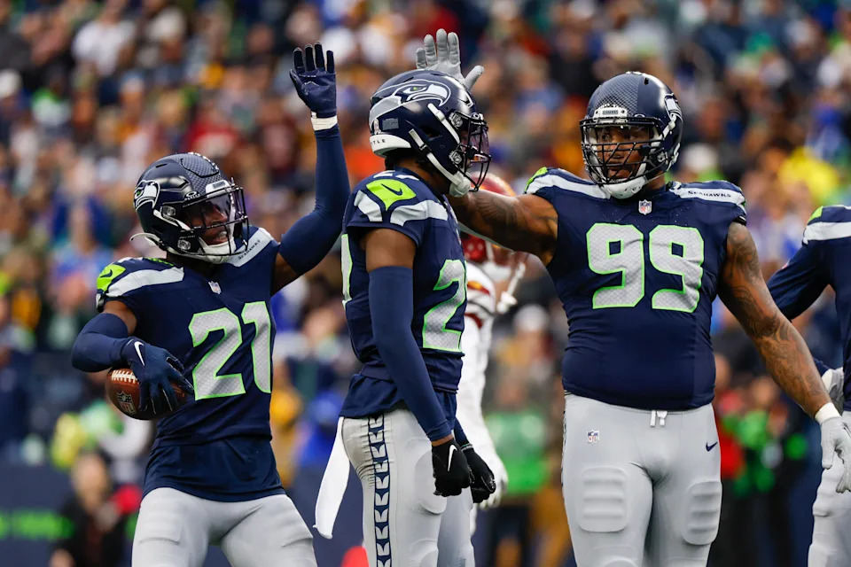 Nov 12, 2023; Seattle, Washington, USA; Seattle Seahawks cornerback Devon Witherspoon (21), cornerback Riq Woolen (27) and defensive end Leonard Williams (99) celebrate following a play against the Washington Commanders during the second quarter at Lumen Field. Mandatory Credit: Joe Nicholson-USA TODAY Sports