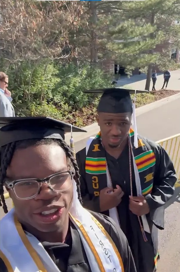 Two graduates in caps and gowns.