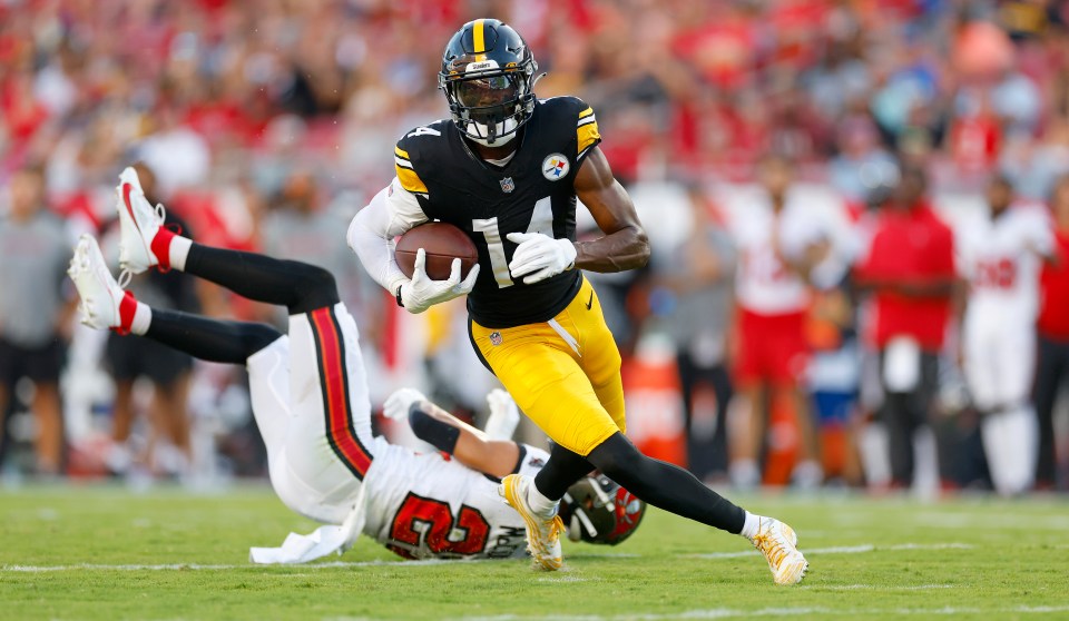 George Pickens, #14, running with the football during a football game.