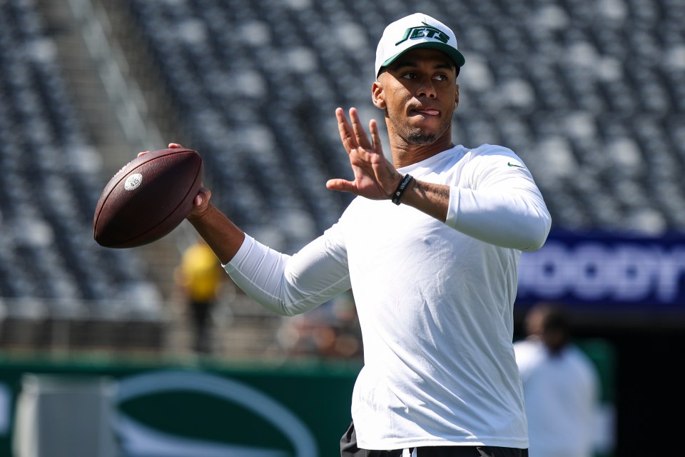 New York Jets quarterback Jordan Travis warming up with a football.