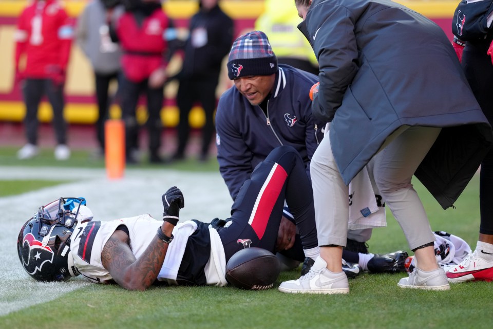 Medical staff attending to an injured Houston Texans football player on the field.