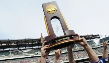 lacrosse players' hands holding up a national championship trophy at lincoln financial field in philadelphia