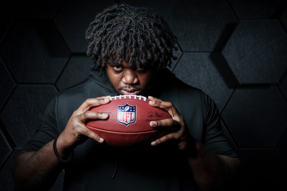 Portrait of Armand Membou, Missouri Tigers offensive lineman, holding an NFL football.