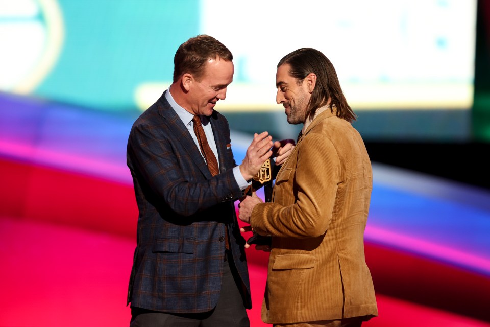 Peyton Manning presenting an award to Aaron Rodgers.