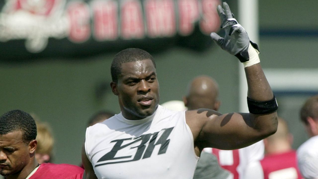Former Tampa Bay Buccaneers defensive end Simeon Rice acknowledges the crowd as he leaves the practice field in Lake Buena Vista, Fla., on Wednesday, Aug. 4, 2004. (AP Photo/Peter Cosgrove)