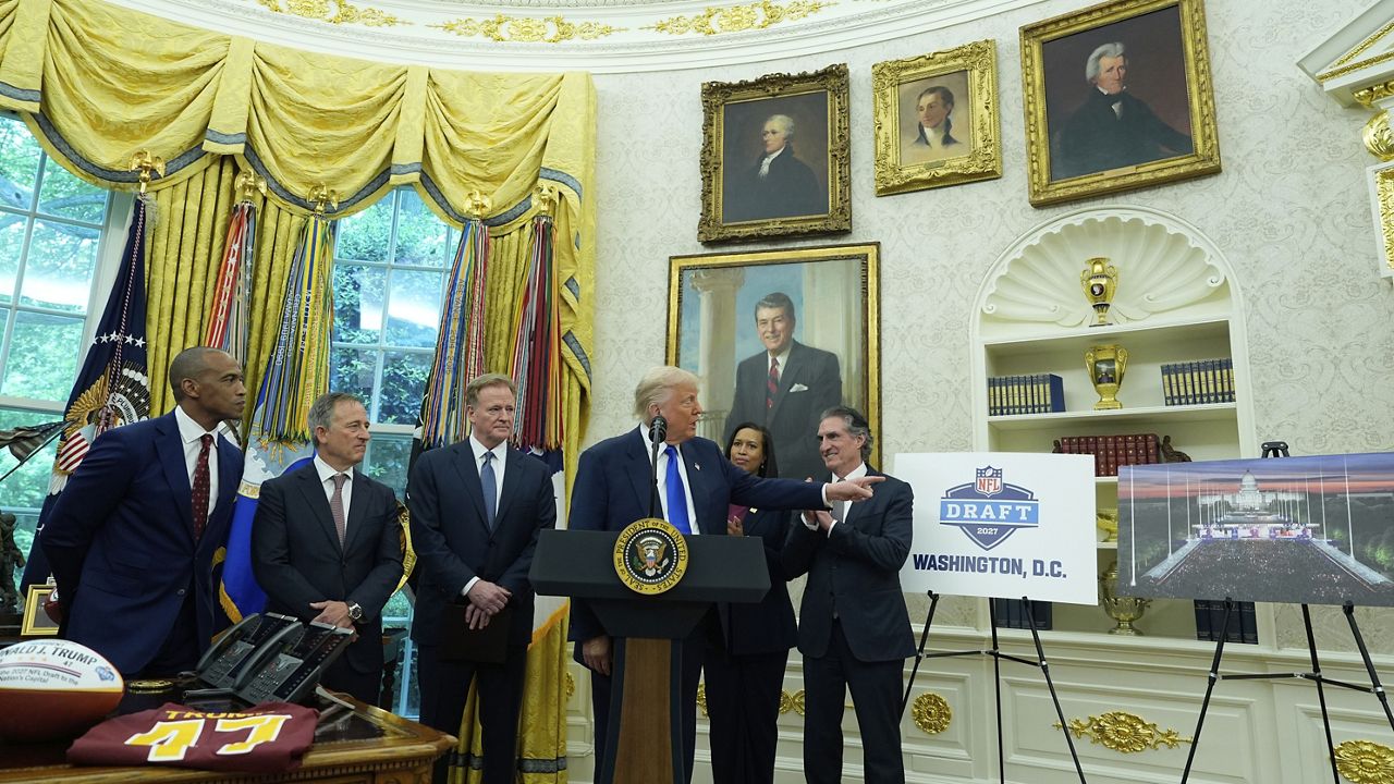 Interior Secretary Doug Burgum, from right, District of Columbia Mayor Muriel Bowser, and from left, Secretary of Housing and Urban Development Scott Turner, Washington Commanders owner Josh Harris and NFL Commissioner Roger Goodell listen as President Donald Trump speaks during an event to announce that the 2027 NFL Draft will be held on the National Mall, in the Oval Office of the White House, Monday, May 5, 2025, in Washington. (AP Photo/Alex Brandon)