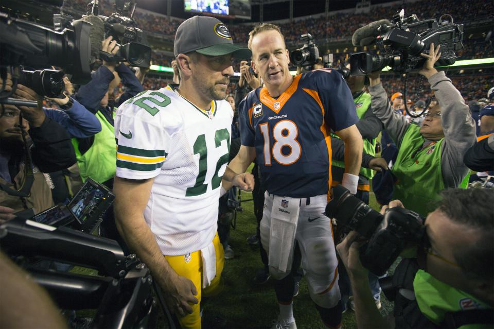 Peyton Manning and Aaron Rodgers shaking hands after a football game.