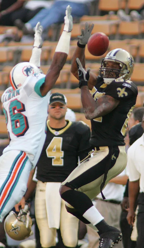 Oct. 30, 2005; New Orleans Saints receiver Joe Horn (87) pulls in a pass against the Miami Dolphins Travares Tillman (26). Mandatory Credit: John David Mercer-Imagn Images © 2005 John David Mercer