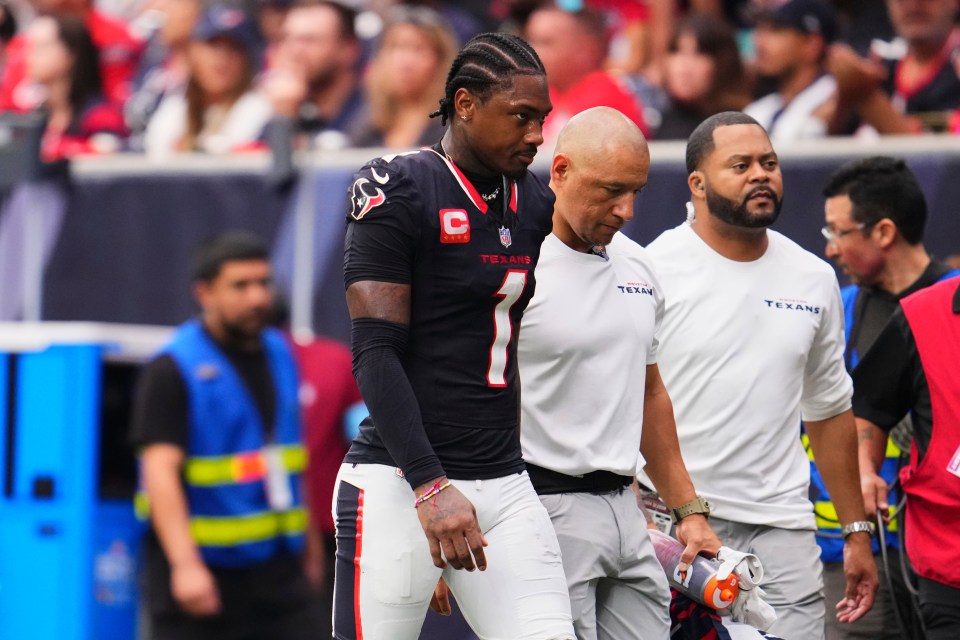 Stefon Diggs #1 of the Houston Texans walks to the locker room with a trainer.