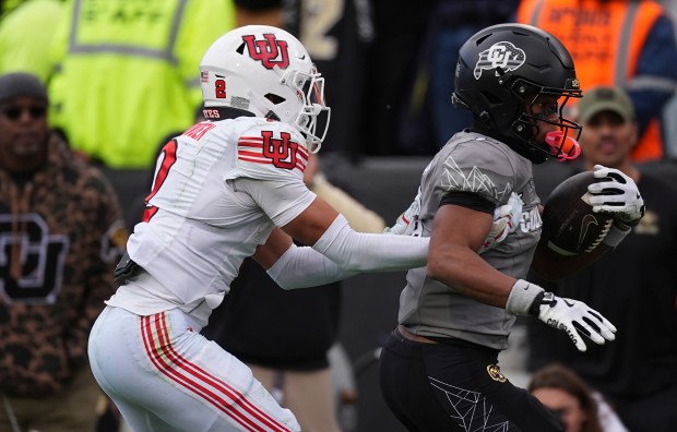 Utah cornerback Smith Snowden, left, pulls down Colorado wide receiver Drelon Miller after catching a pass for a long gain in the second half of an NCAA college football game Saturday, Nov. 16, 2024, in Boulder, Colo. (AP Photo/David Zalubowski)
