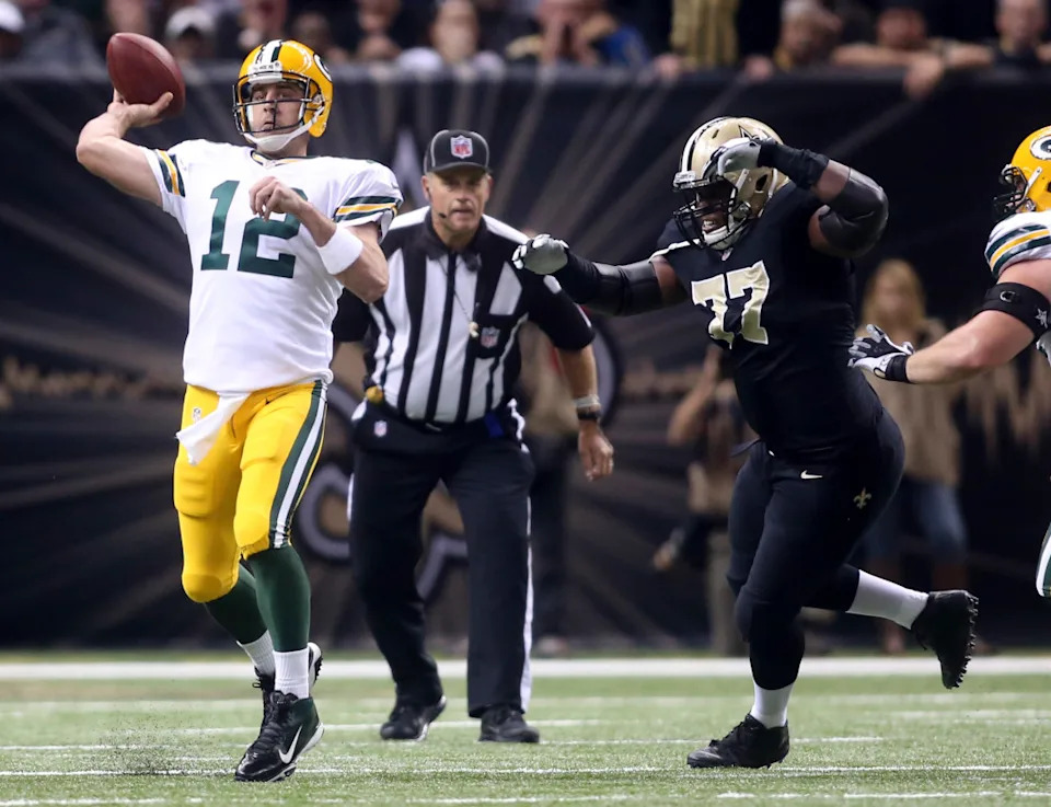 Oct 26, 2014; Green Bay Packers quarterback Aaron Rodgers (12) is pressured by New Orleans Saints nose tackle Brodrick Bunkley (77). Mandatory Credit: Crystal LoGiudice-Imagn Images