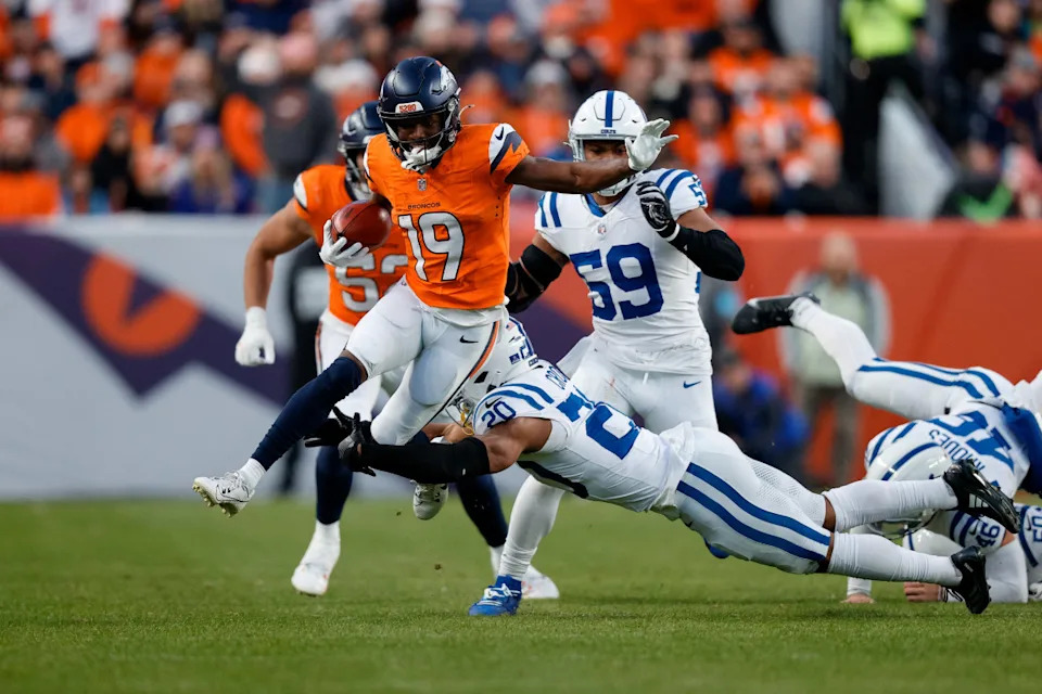 Denver Broncos wide receiver Marvin Mims Jr. (19) runs through the tackle of Indianapolis Colts safety Nick Cross (20) in the third quarter at Empower Field at Mile High.Isaiah J&period; Downing-Imagn Images