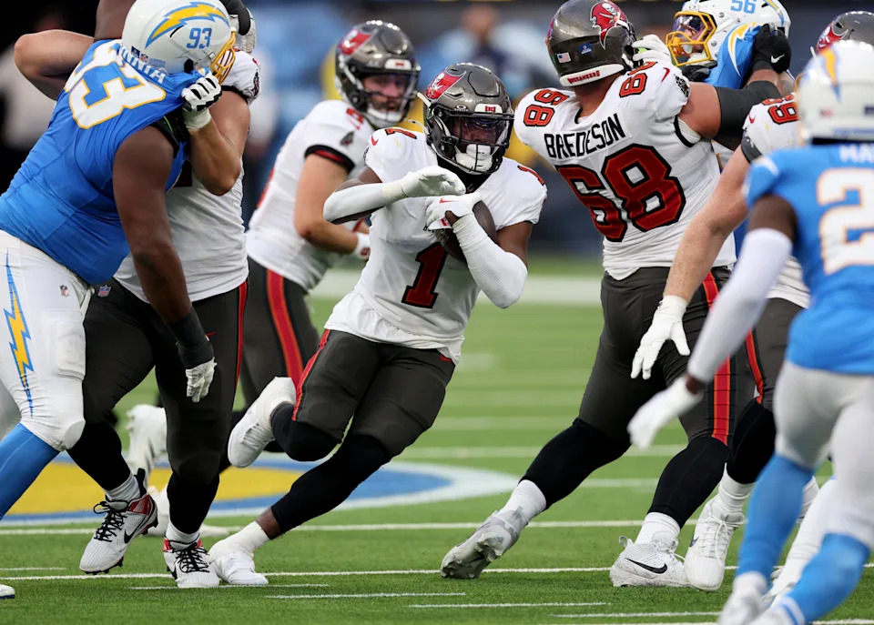 INGLEWOOD, CALIFORNIA - DECEMBER 15: Rachaad White #1 of the Tampa Bay Buccaneers runs around a block from Ben Bredeson #68 during a 40-17 win over the Los Angeles Chargers at SoFi Stadium on December 15, 2024 in Inglewood, California. (Photo by Harry How/Getty Images)