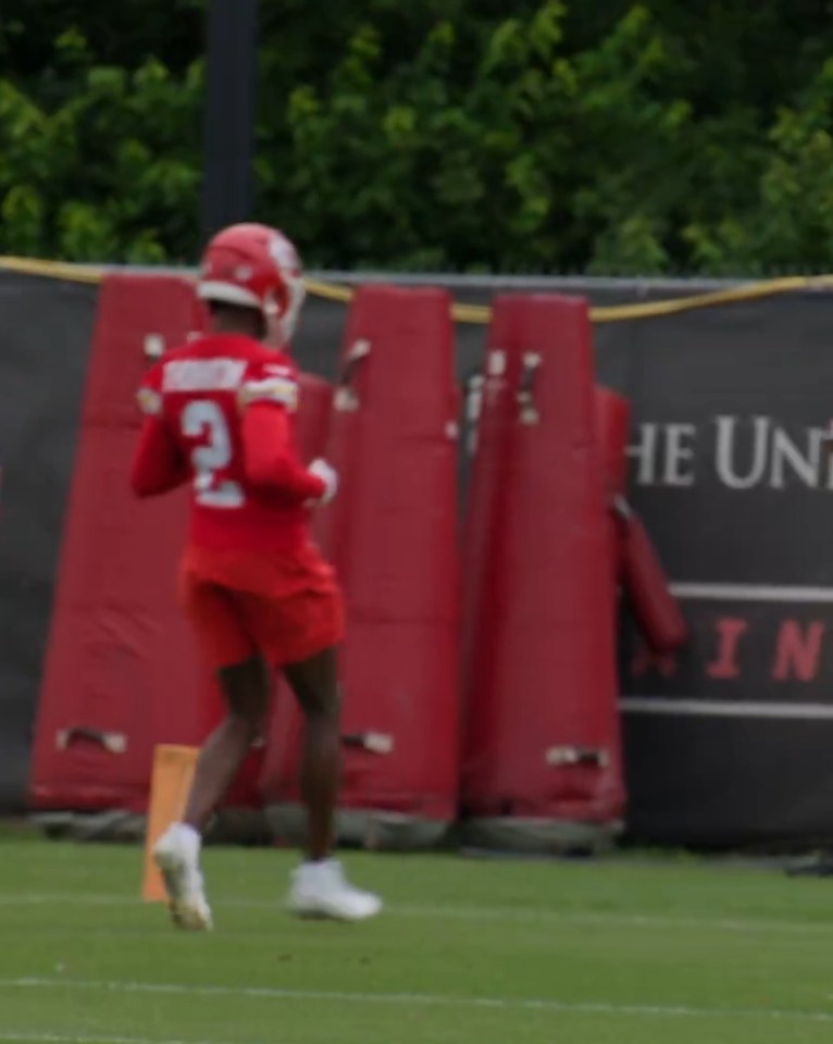 Football player in red jersey running on field.