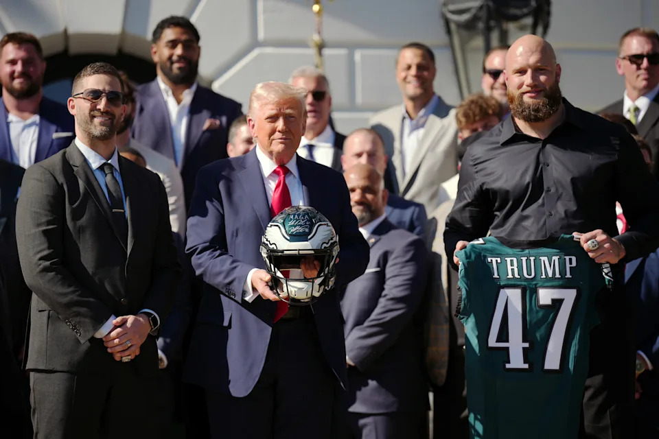 Trump posing with a bunch of Eagles players at an event