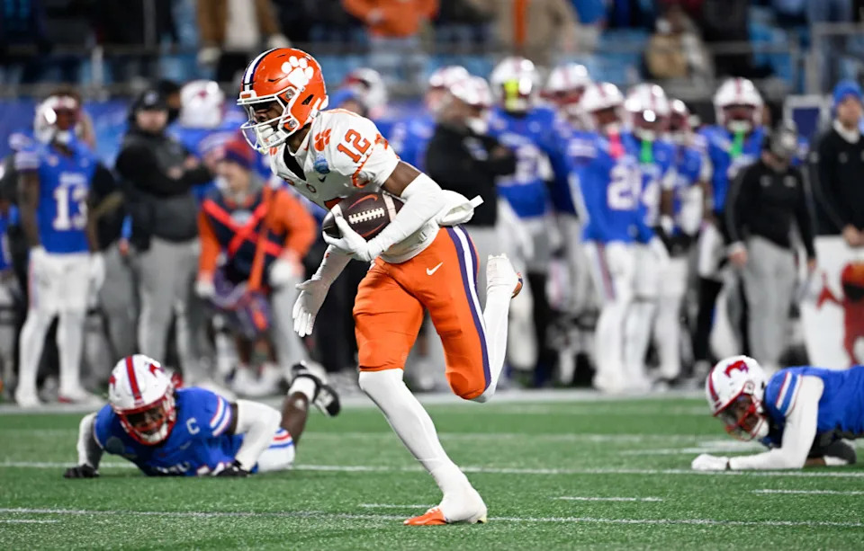 Clemson Tigers wide receiver Bryant Wesco Jr. (12) makes a catch and scores a touchdown against Southern Methodist Mustangs cornerback Deuce Harmon (7) and Southern Methodist Mustangs linebacker Kobe Wilson (24) during the first quarter in the 2024 ACC Championship game at Bank of America Stadium.Mandatory Credit&colon; Bob Donnan-Imagn Images