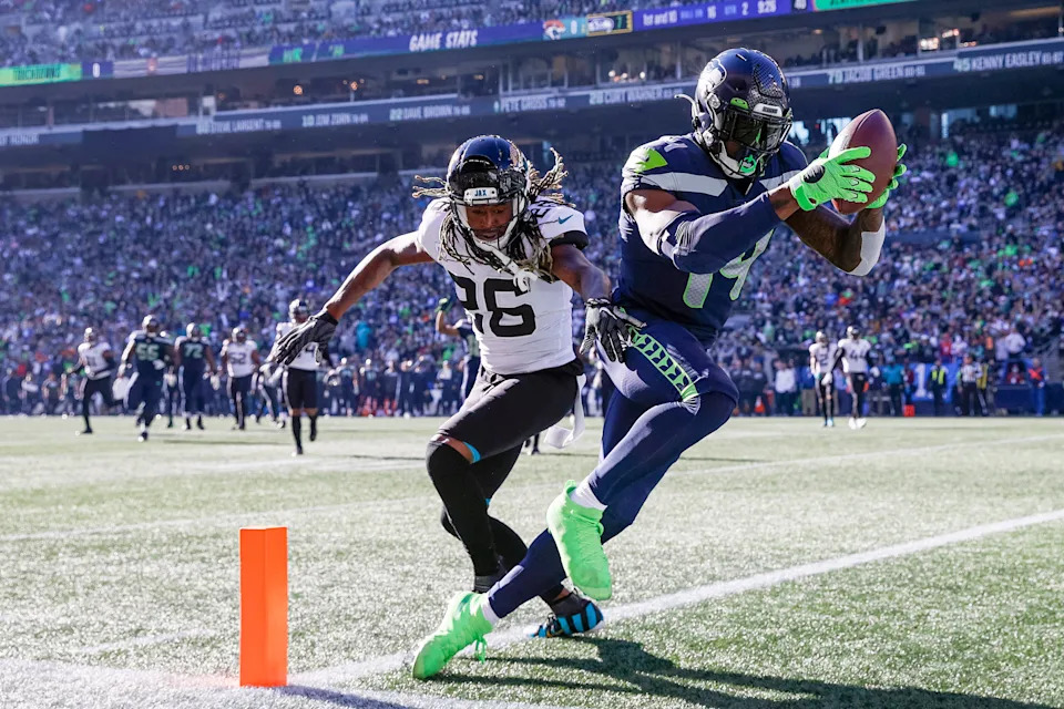 SEATTLE, WASHINGTON - OCTOBER 31: DK Metcalf #14 of the Seattle Seahawks catches the ball over Shaquill Griffin #26 of the Jacksonville Jaguars for a touchdown during the second quarter at Lumen Field on October 31, 2021 in Seattle, Washington. (Photo by Steph Chambers/Getty Images)