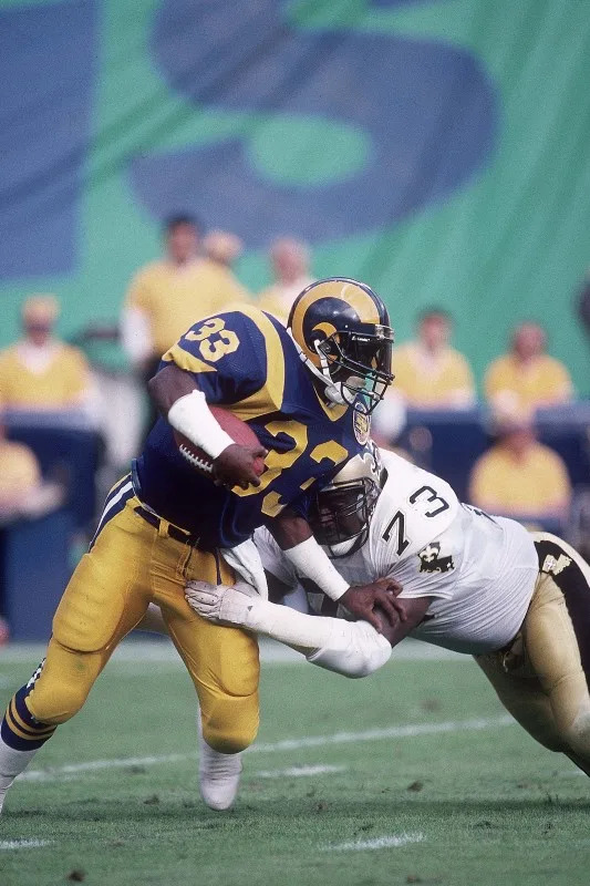 Nov 13, 1988; FILE PHOTO; New Orleans Saints defensive end Frank Warren (73) tackles Los Angeles Rams running back Charles White (33). Mandatory Credit: Peter Brouillet-USA TODAY NETWORK