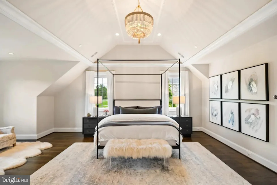 The primary bedroom comes complete with a sunken ceiling, large windows, and a seating nook to the right of the bed.<p class="credit">(Realtor.com)</p>