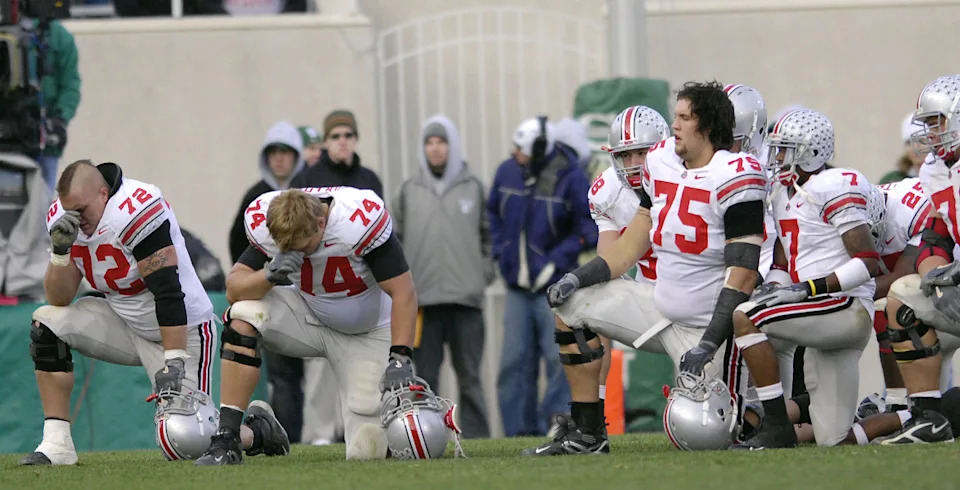 Ohio State offensive guard T.J. Downing, left, and offensive tackle Kirk Barton take a knee and pray for Spartan cornerback Greg Cooper who was being attended to by medical staff on the field during the game between the Michigan State Spartans and the Ohio State Buckeyes at Spartan Stadium in East Lansing, Michigan on Saturday, October 14, 2006. The Buckeyes won the game, 38-7. (Photo by S. Levin/Getty Images)S&period; Levin&sol;Getty Images