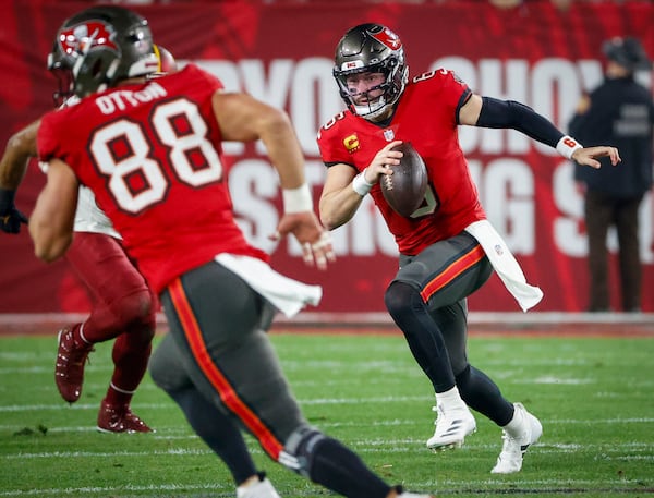 Tampa Bay Buccaneers quarterback Baker Mayfield, right, runs the ball during the first half against the Washington Commanders Sunday, Jan. 12, 2025, at Raymond James Stadium in Tampa, Florida. (Jefferree Woo/Tampa Bay Times/TNS)