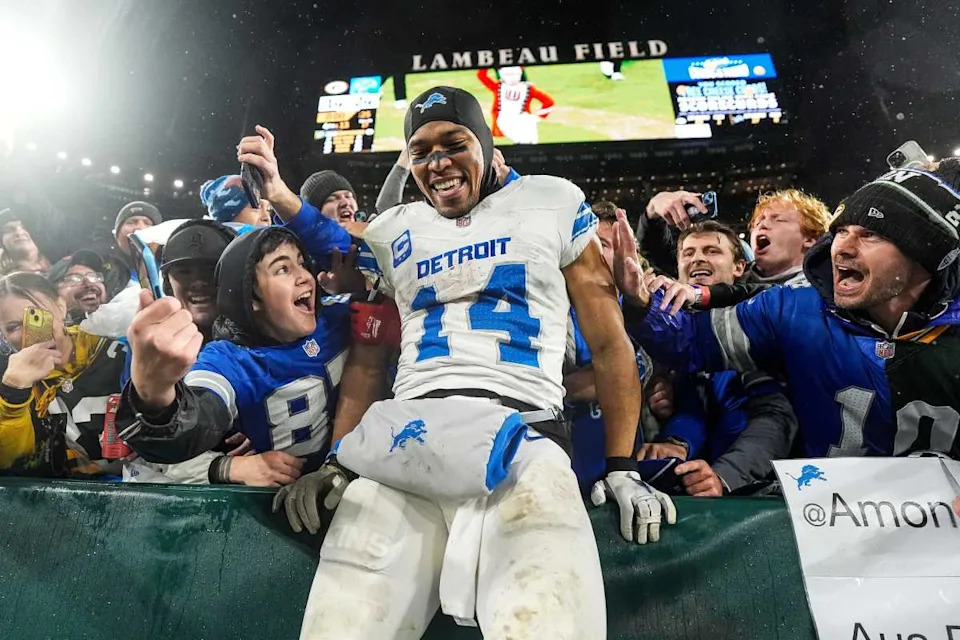 Detroit Lions wide receiver Amon-Ra St. Brown (14) leaps into the crowd to celebrate with fans against the Green Bay Packers. Junfu Han / USA TODAY NETWORK via Imagn Images