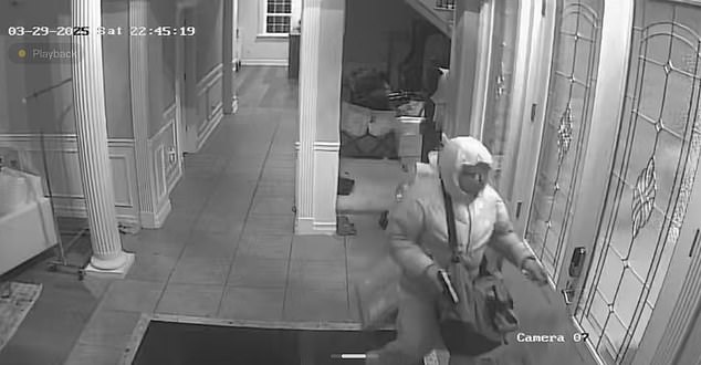 One of the robbers is seen holding a pistol in his right hand as he approaches the door