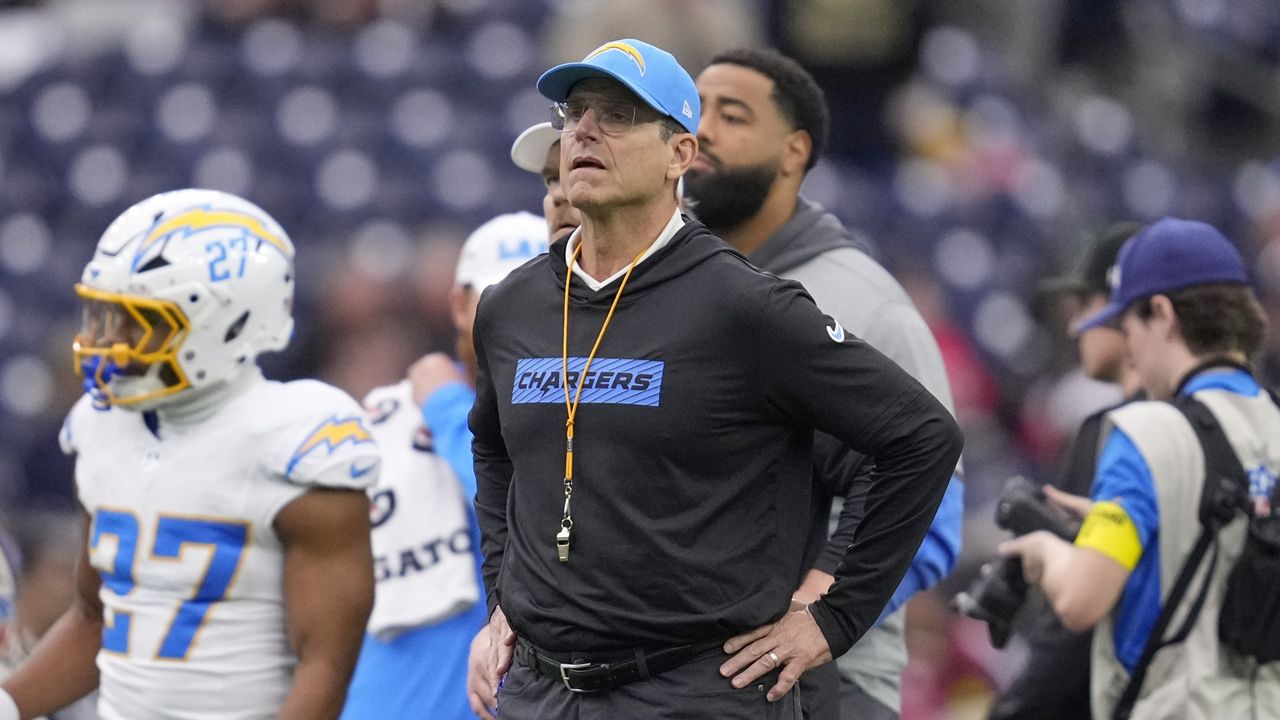Los Angeles Chargers coach Jim Harbaugh watches players warm up before an NFL wild-card playoff football game against the Houston Texans, Jan. 11, 2025, in Houston. (AP Photo/Ashely Landis, File)