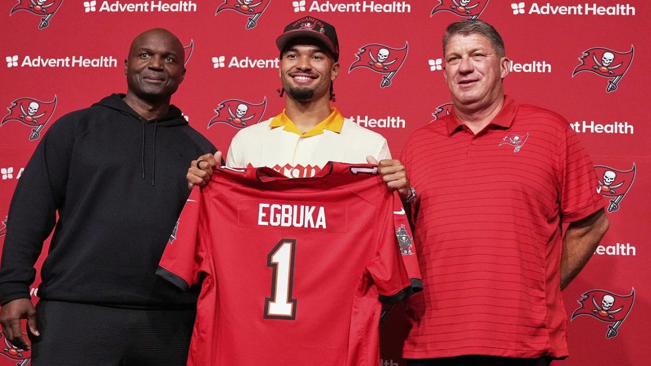 Tampa Bay Bucs first round draft pick Emeka Egbuka holds up a jersey with head coach Todd Bowles (right) and GM Jason Licht. Egbuka and the Bucs wrapped up their three-day mini camp on Thursday. (AP Photo/Chris O'Meara)