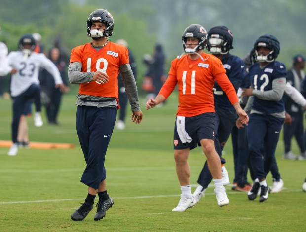 Quarterbacks Caleb Williams (18) and Case Keenum (stretch during Bears minicamp at Halas Hall on June 4, 2025, in Lake Forest. (Stacey Wescott/Chicago Tribune)
