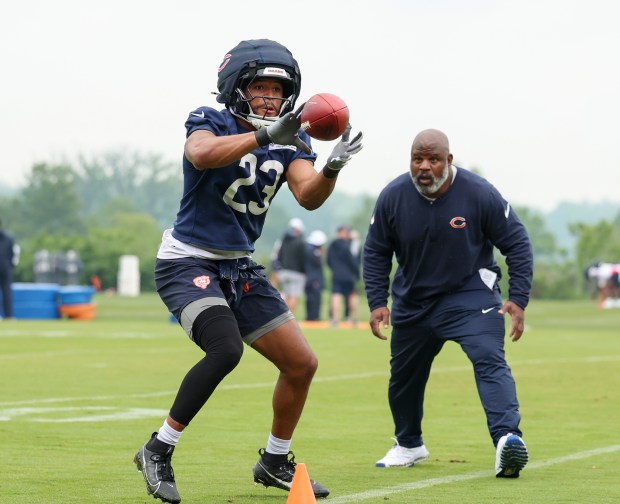 Chicago Bears running back Roschon Johnson (23) catches a pass while Chicago Bears running backs coach is Eric Bieniemy looks on during Chicago Bears minicamp at Halas Hall on June 4, 2025, in Lake Forest. (Stacey Wescott/Chicago Tribune)