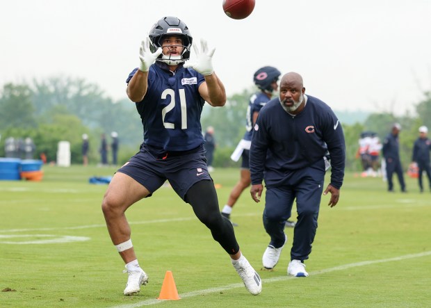 Running back Travis Homer catches a pass while running backs coach Eric Bieniemy looks on during Bears minicamp at Halas Hall on June 4, 2025, in Lake Forest. (Stacey Wescott/Chicago Tribune)