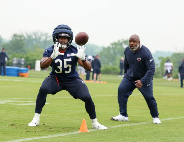 Running back Deion Hankins catches a pass while running backs coach Eric Bieniemy looks on during Bears minicamp at Halas Hall on June 4, 2025, in Lake Forest. (Stacey Wescott/Chicago Tribune)