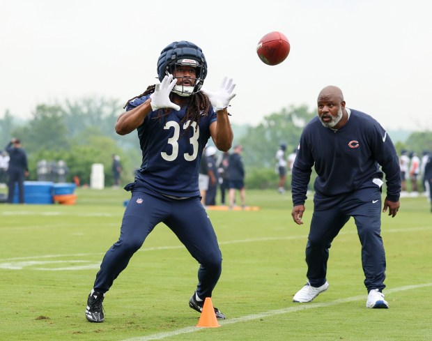 Running back Ian Wheeler catches a pass in front of running backs coach Eric Bieniemy during Bears minicamp at Halas Hall on June 4, 2025, in Lake Forest. (Stacey Wescott/Chicago Tribune)