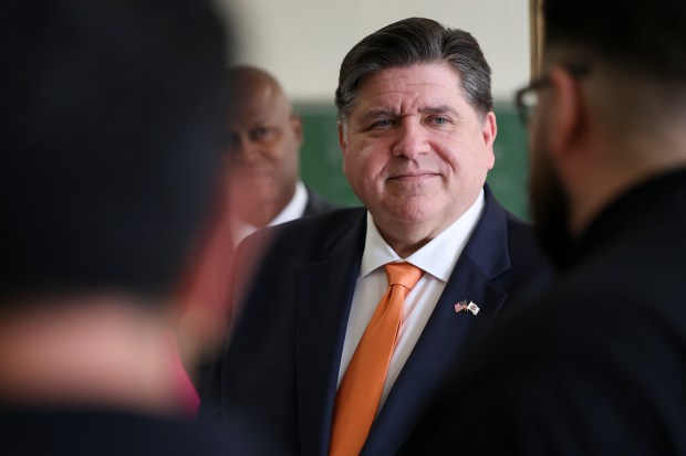 Gov. J.B. Pritzker listens to RR Trade School instructor Chris Martinez describe their programs and students before a press conference at RR Trade School in Melrose Park on April 14, 2025. (Eileen T. Meslar/Chicago Tribune)